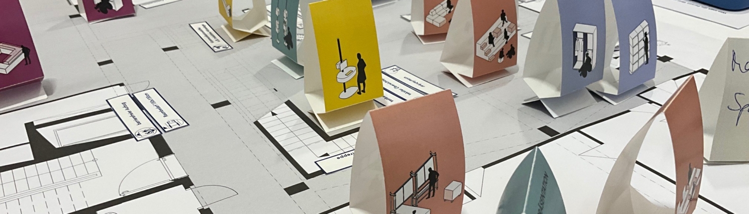 Grundriss eines Bibliothekseingangs mit Papieraufstellern zum Ausprobieren